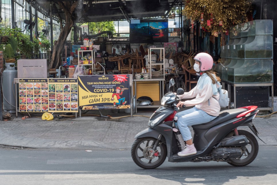 오토바이를 타는 마스크를 쓴 여성